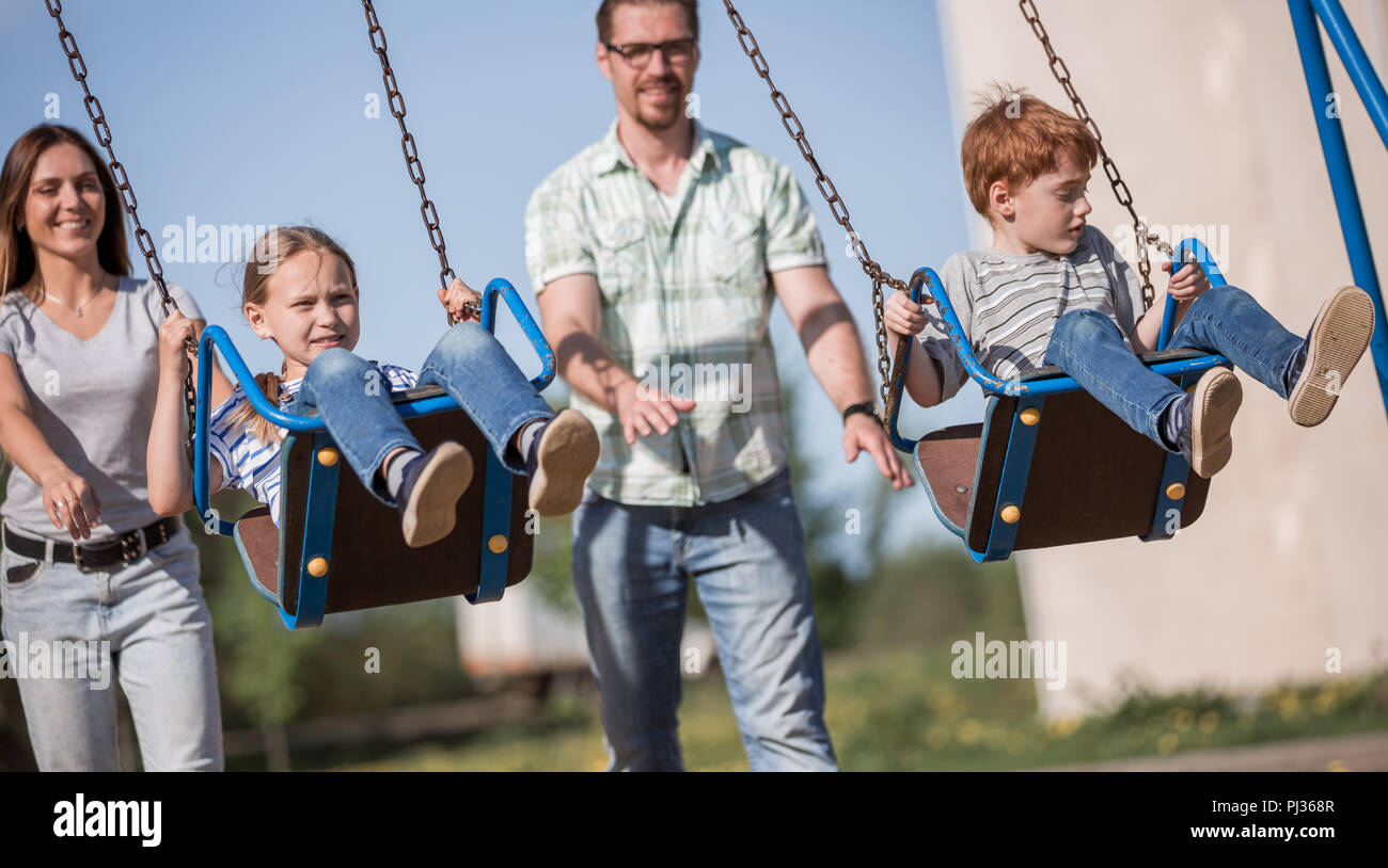 couple with two children playing in the Playground Stock Photo