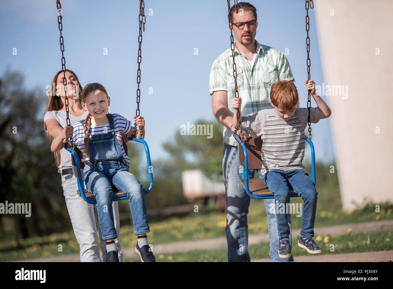 couple with two children playing in the Playground Stock Photo