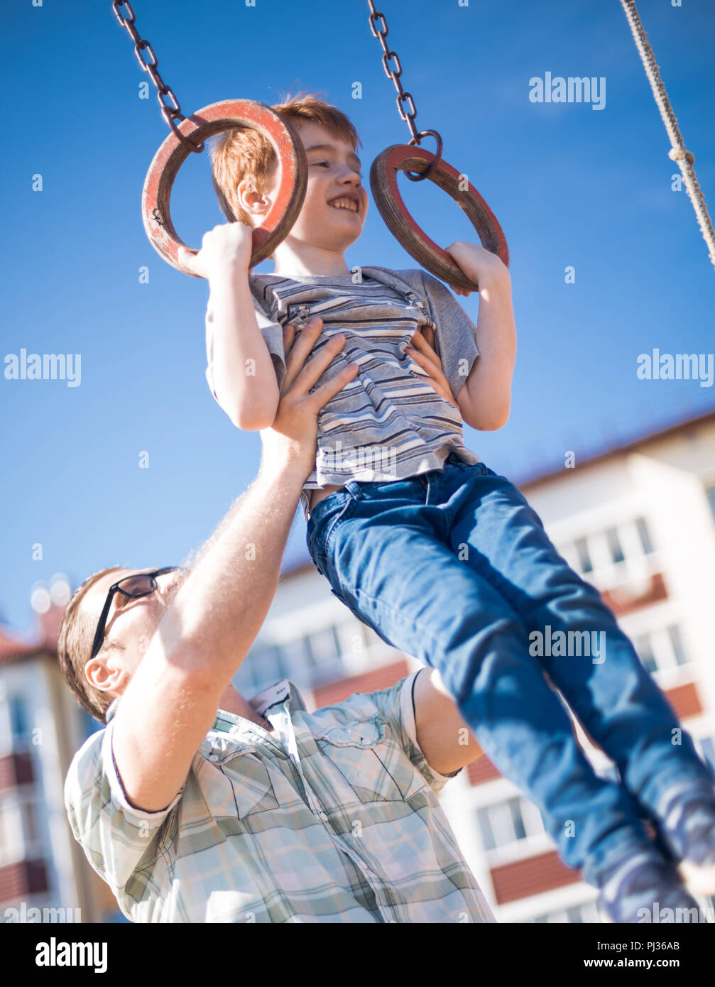 father teaches his son to catch up on the bar. Stock Photo