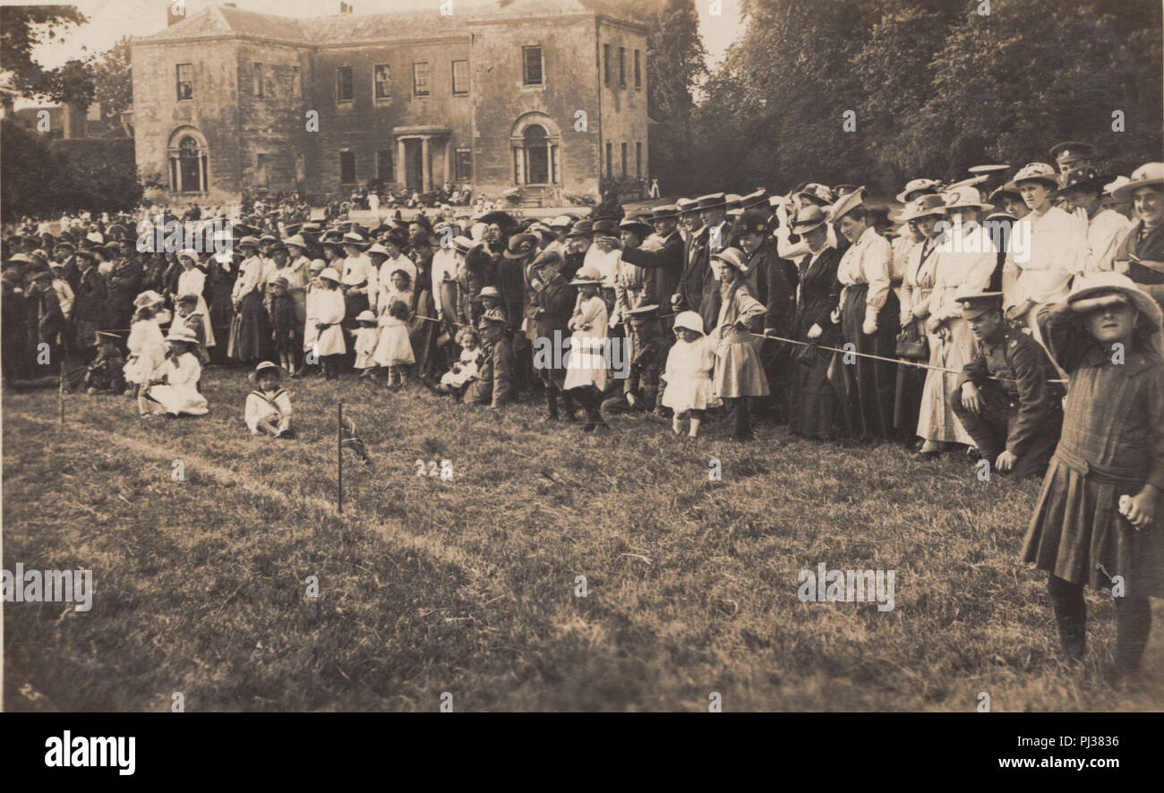 Vintage Photograph of a Stately Home Celebration or Sports Event. Crowd of Adults and Children Enjoying The Event. Stock Photo