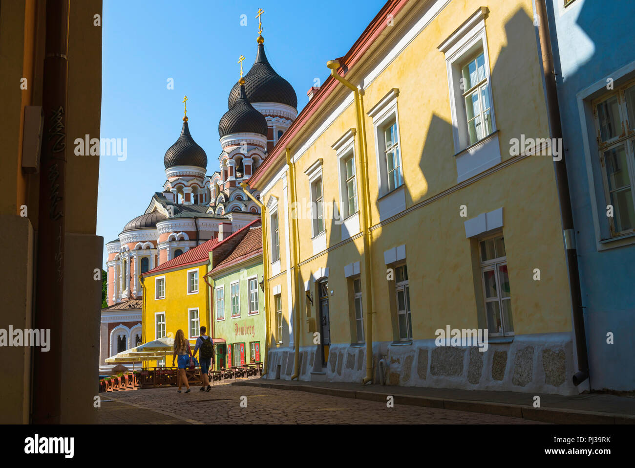 Young people travel, view in summer of two young people walking along a colorful street on Toompea Hill in Tallinn, Estonia. Stock Photo