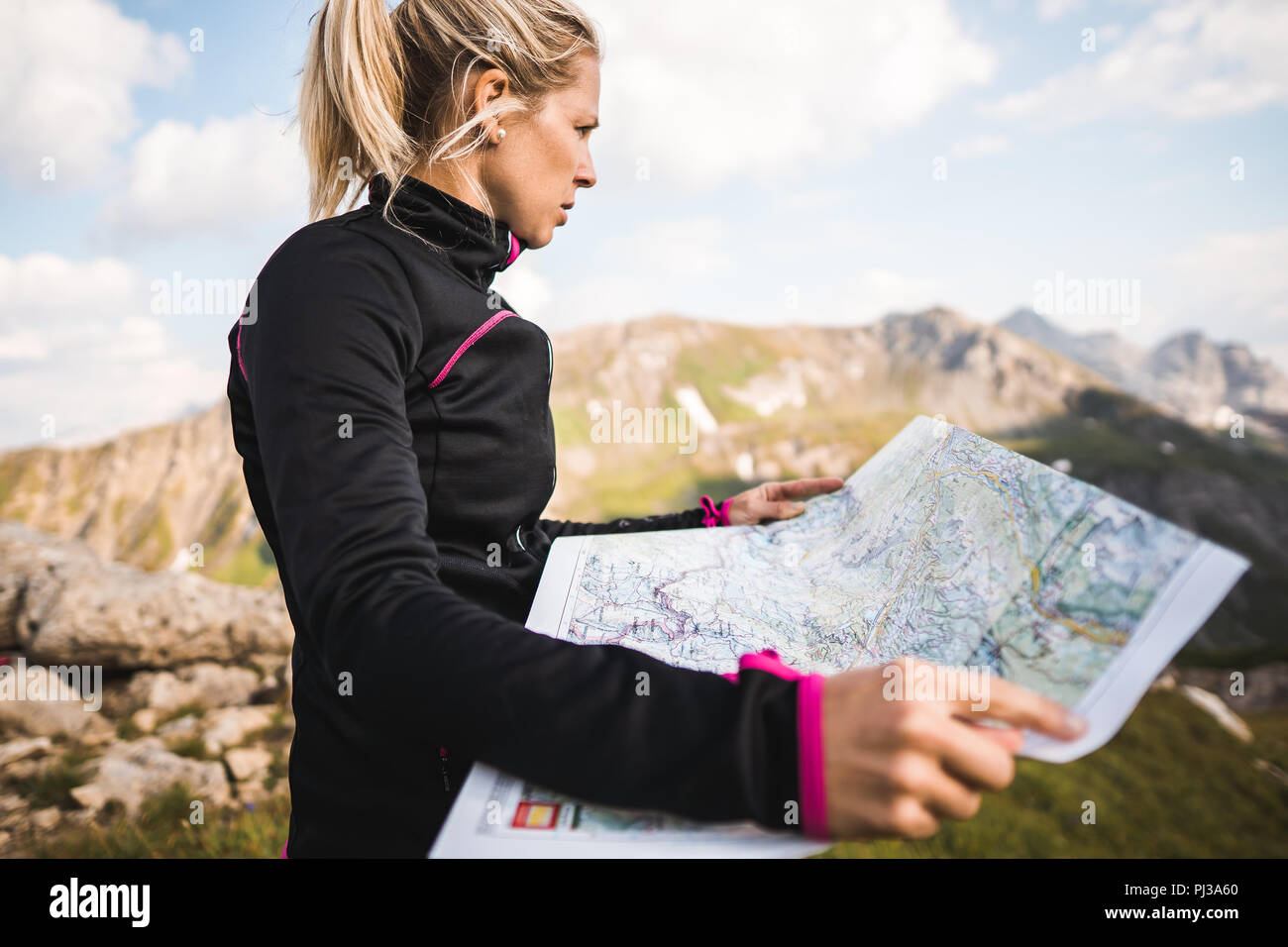 Adventurous Hiker Girl navigating in the Mountains Stock Photo