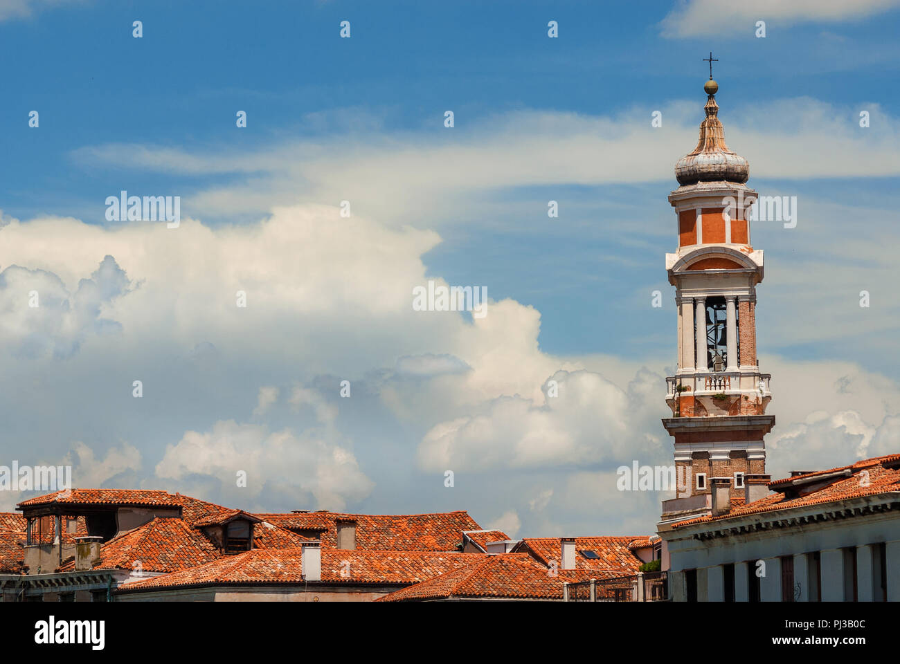 Church of the Holy Apostles of Christ baroque bell tower, built between 17th and 18th century, rise above Venice historic center old buildings among c Stock Photo
