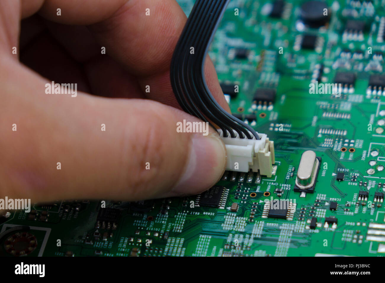 Quality control and assembly of SMT printed components on circuit board in QC lab of PCB manufacturing high-tech factory Stock Photo