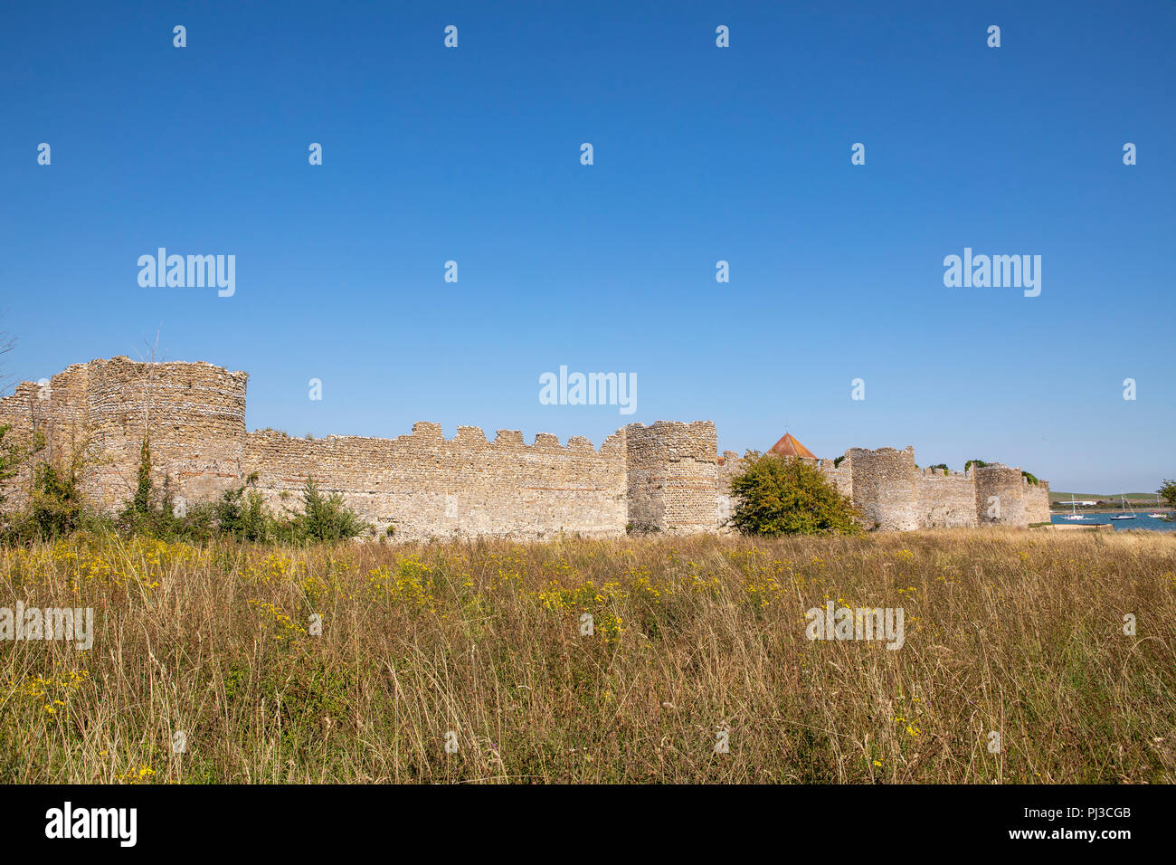Outside the impressive walls of Portchester Castle near Portsmouth in Hampshire. Clear blue skies above the medieval stronghold. Stock Photo