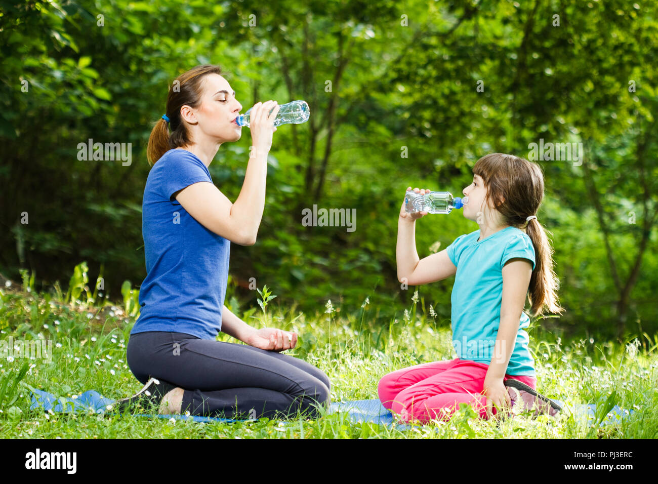 Mother and daughter drinking water after exercise Stock Photo - Alamy, image size:1300x956