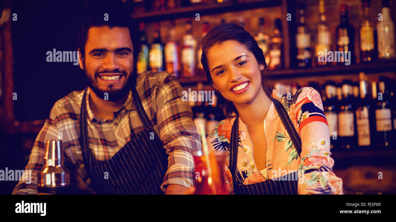 Portrait of happy waiter and waitress standing at counter Stock Photo