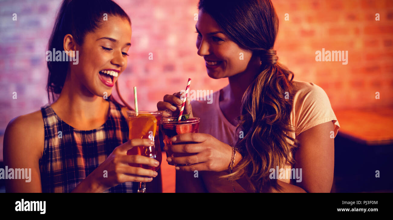 Two young women having cocktail drinks Stock Photo