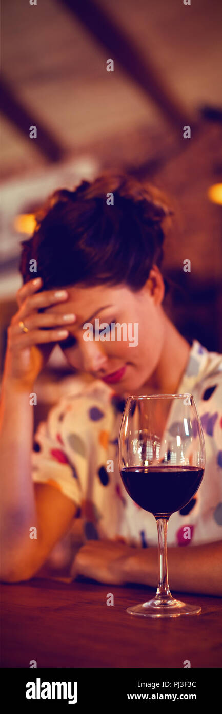 Upset woman sitting with hands on forehead Stock Photo