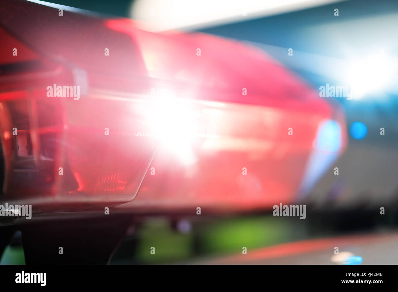 Red flashes on the car of the emergency vehicle at night. Police patrol car of the specialized unity in the night time. Police lights during traffic s Stock Photo