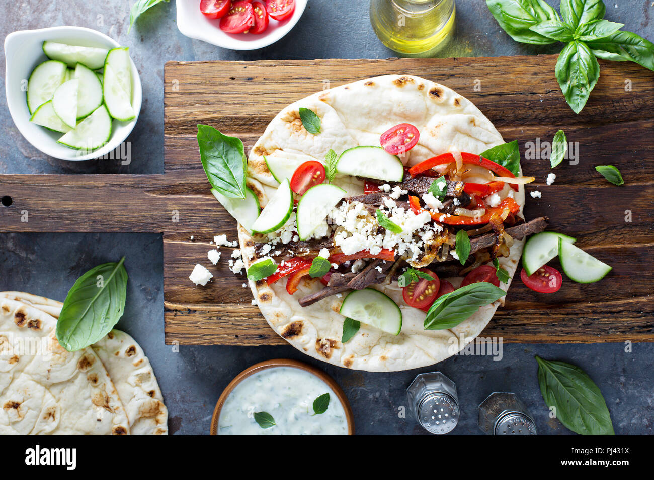 Flatbread with beef, feta cheese and vegetables with tzatziki sauce