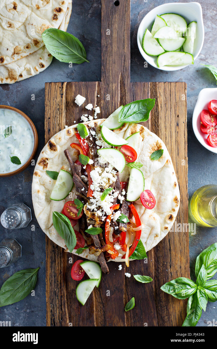 Flatbread with beef, feta cheese and vegetables with tzatziki sauce