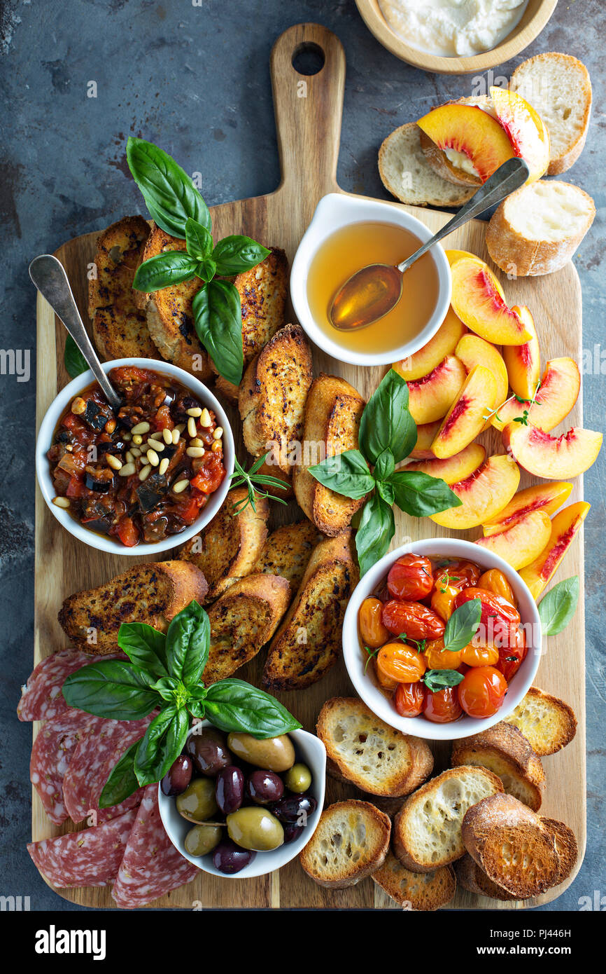 Crostini board with tomatoes, peaches and eggplant caponata dip Stock