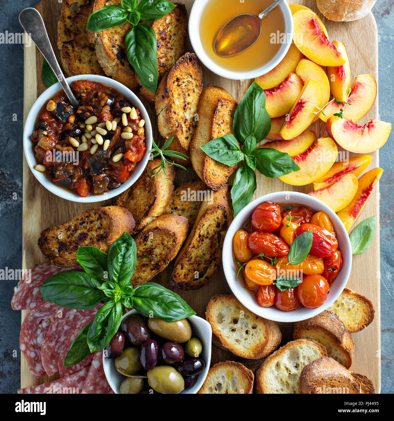 Crostini board with tomatoes, peaches and eggplant caponata dip Stock