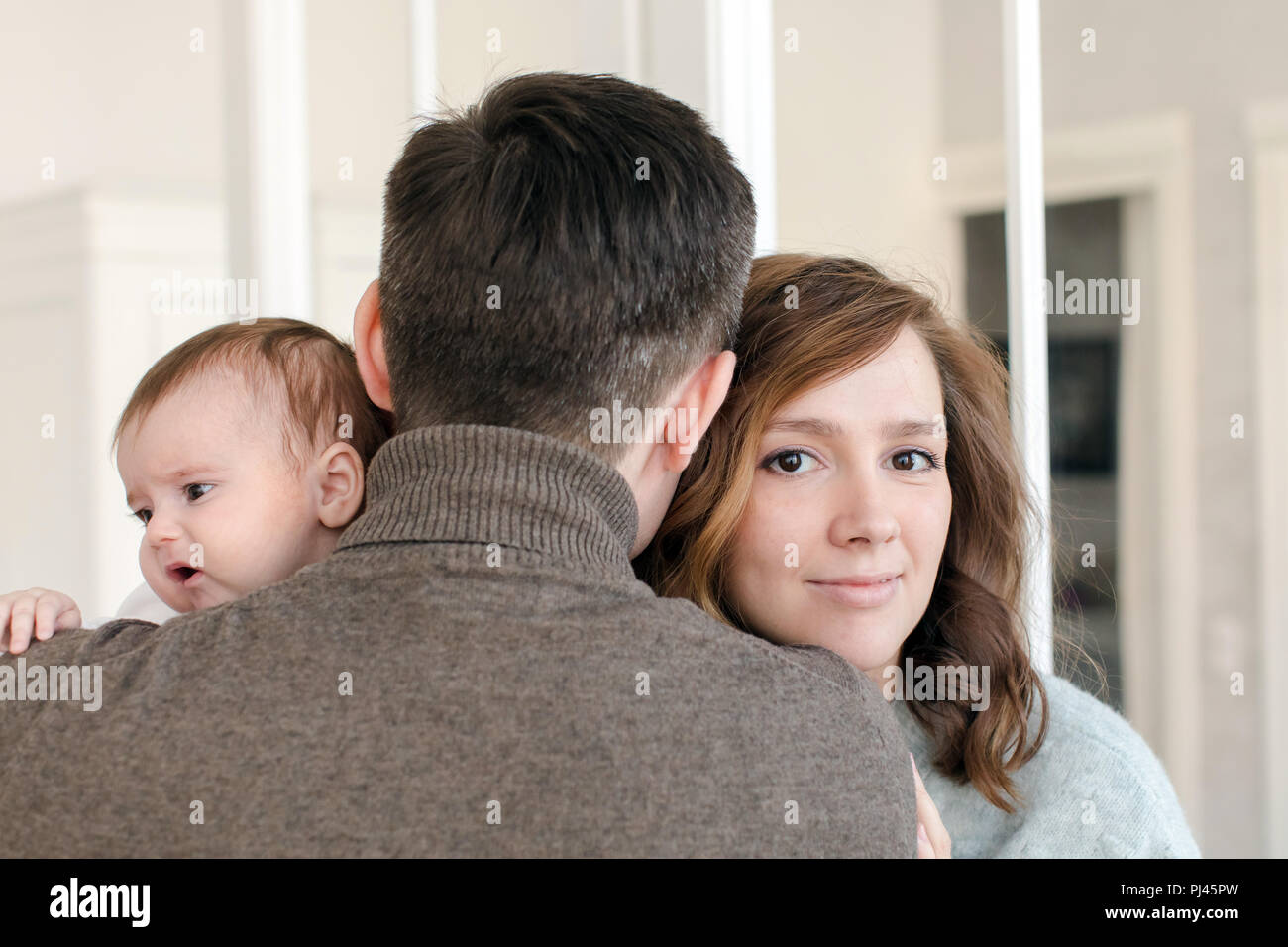 Anonymous man hugging wife and baby Stock Photo