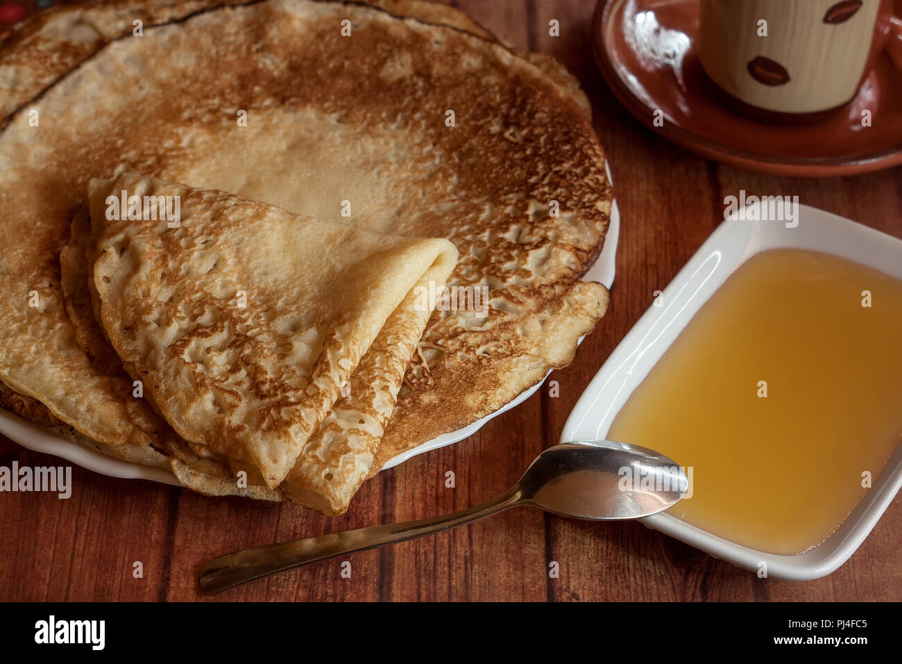 Breakfast pancakes served with honey on wooden table Stock Photo