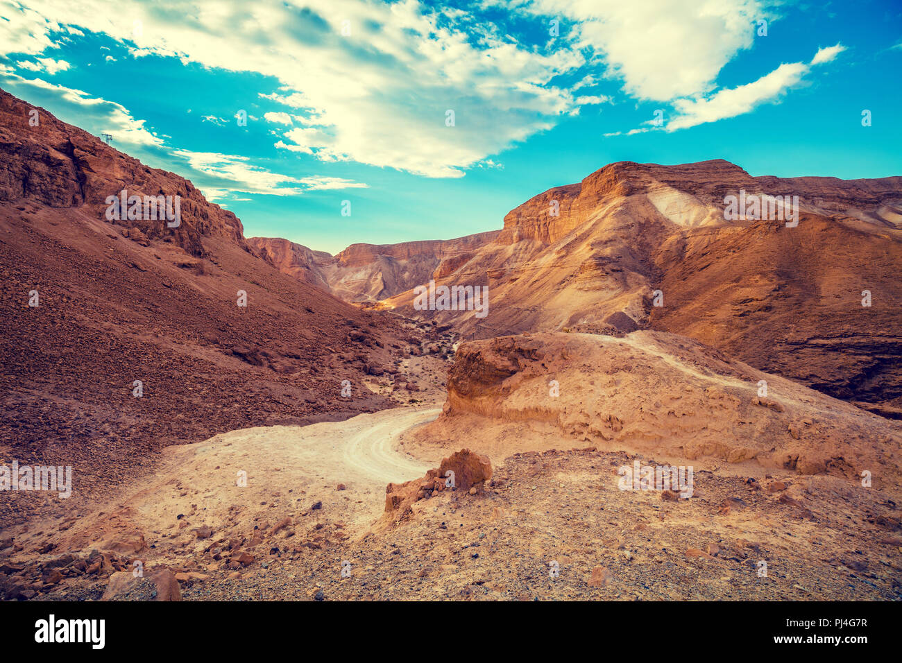 The dirt road among the mountains in the desert. Israel. The beginning of the ascent to Masada from the west side Stock Photo
