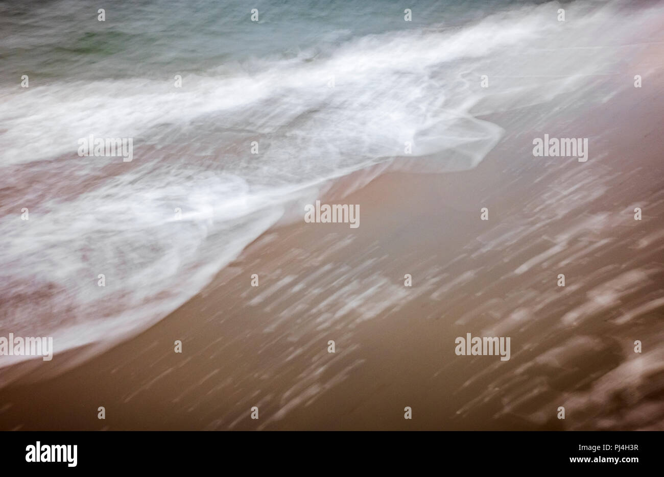 artistic moving blurred background of the foam of the waves that wash up on the beach Stock Photo