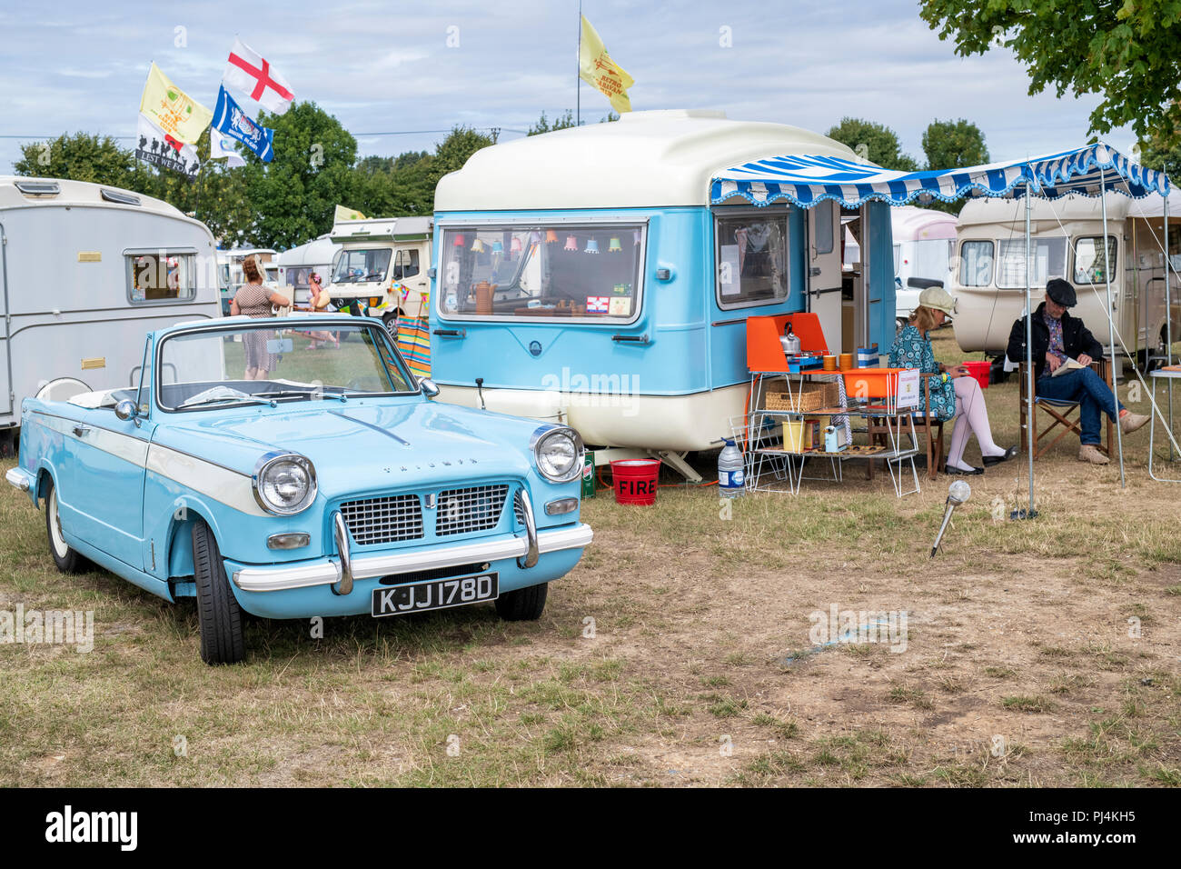 1966 triumph herald 1200 and a vintage caravan at a vintage retro festival. UK Stock Photo
