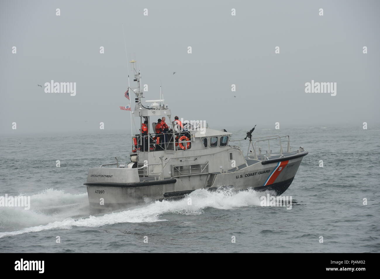 A boat crew aboard a 47-foot Motor Life Boat from Coast Guard Station Cape Disappointment patrols the Pacific Ocean 5 miles west of the Columbia River entrance, near Ilwaco, Wash., Aug. 29, 2018.    The crew was scheduled to do a live-fire training with a mounted M-240 weapons system, but the training was cancelled due to low visibility.    U.S. Coast Guard photo by Petty Officer 1st Class Levi Read. Stock Photo