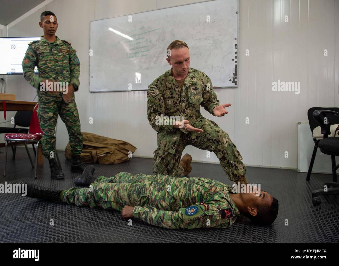 Hospital Corpsman 3rd Class Tom McCarthy, from McKinleyville, California, assigned to Naval Hospital Yokosuka, and members of the Timor-Leste Defense Force simulate checking for bleeding on a patient during CARAT Timor-Leste 2018 at Hera Naval Base, Aug. 29, 2018. CARAT Timor-Leste 2018 is designed to address shared maritime security concerns, build relationships and enhance interoperability among participating forces. (U.S. Navy photo by Mass Communication Specialist 3rd Class Danny Ray Nuñez Jr./Released) Stock Photo