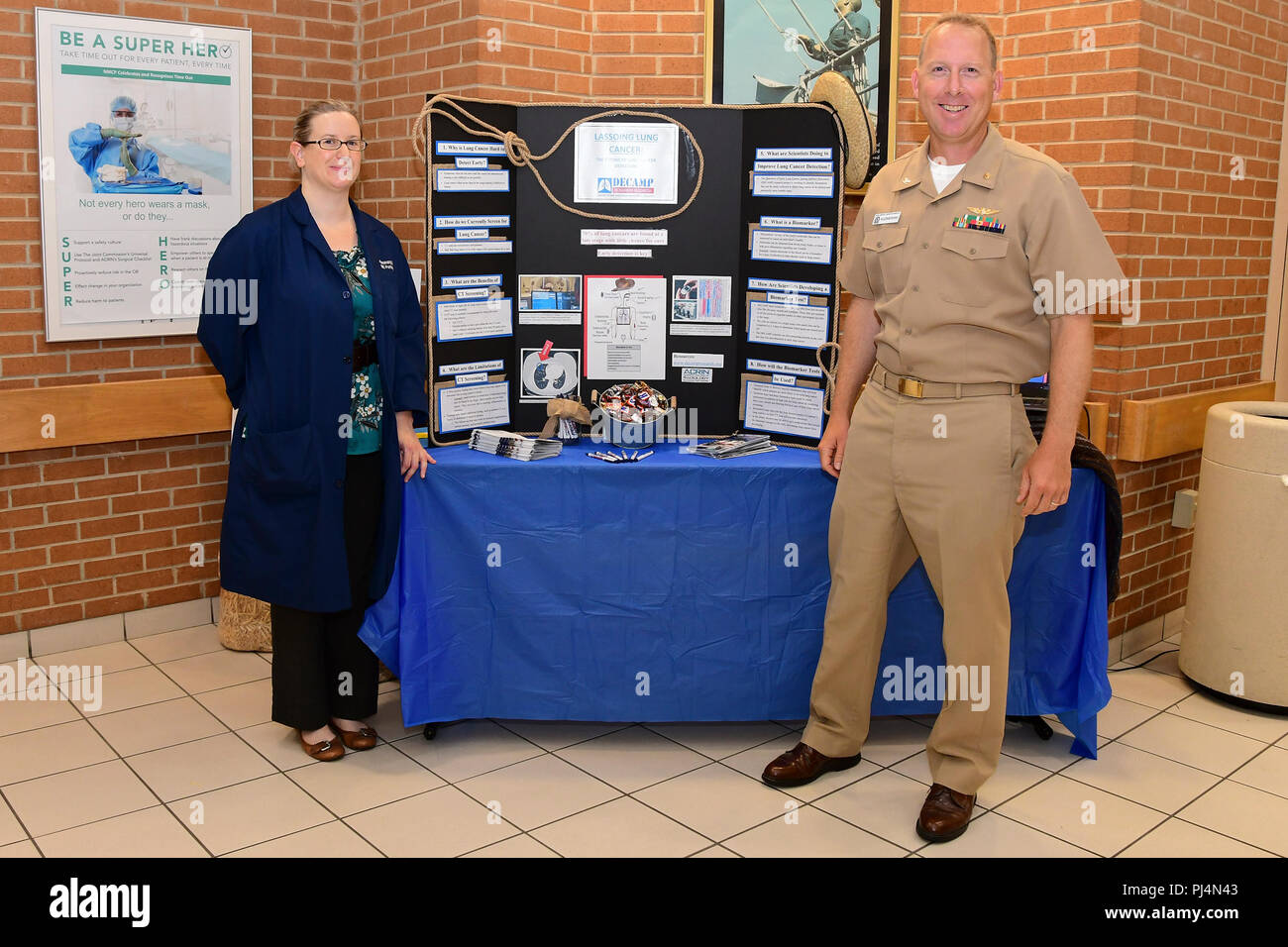 180830-N-IY469-002 – Holly LaPerriere and Capt. Chris Kuzniewski set up a booth to promote their research on lung cancer. LaPerriere is a research nurse and coordinator and Kuzniewski is the primary investigator for Detection of Early Lung Cancer Among Military Personnel (DECAMP). Stock Photo