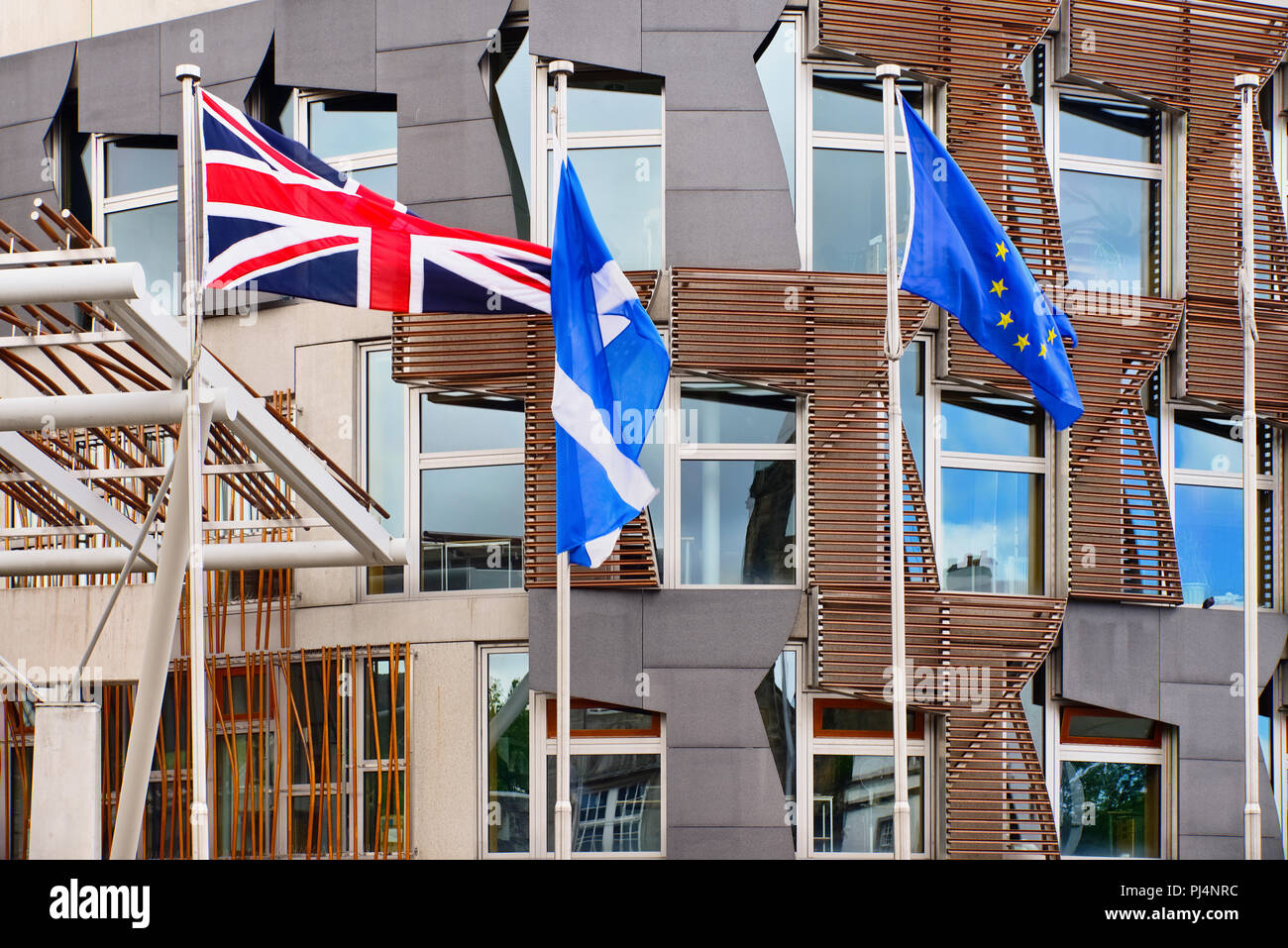 Scotland, Edinburgh, Scottish Parliament Building with Union Jack Scottish and EU flags outside. Stock Photo