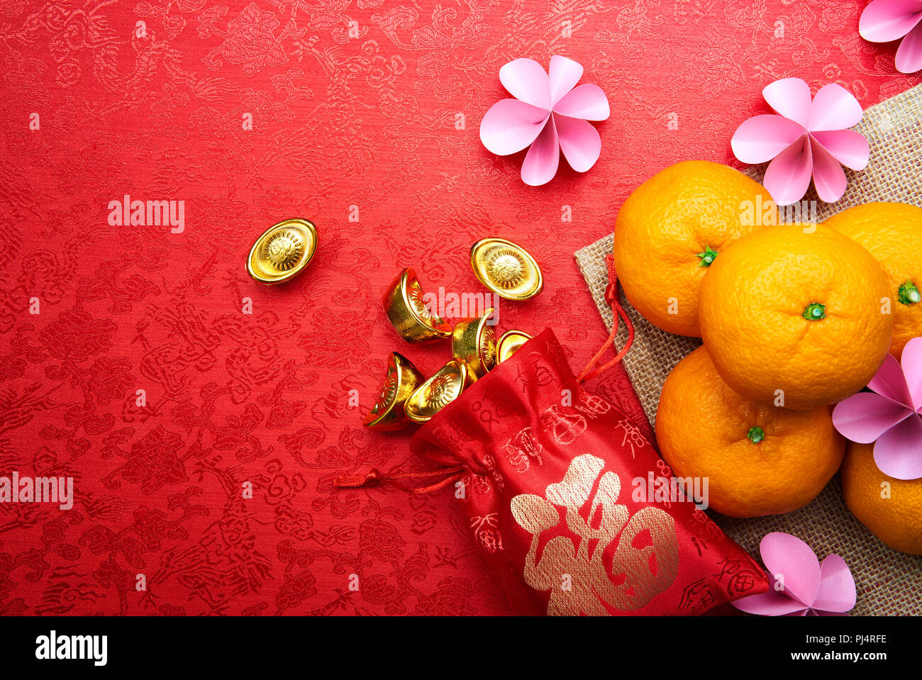 Chinese New Year decoration - Chinese calligraphy on gold sycee and red pouch means 'Prosperity' Stock Photo