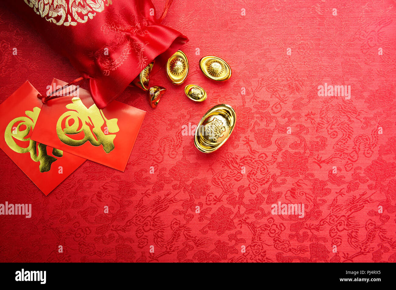 Chinese New Year decoration - Gold sycee (Foreign text means wealth) and red packet (Foreign text means Prosperity) Stock Photo