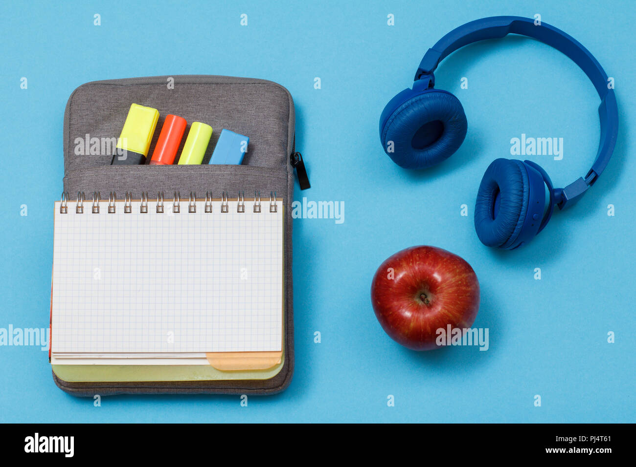 Open exercise book on bag-pencil case with color felt pens and marker ...
