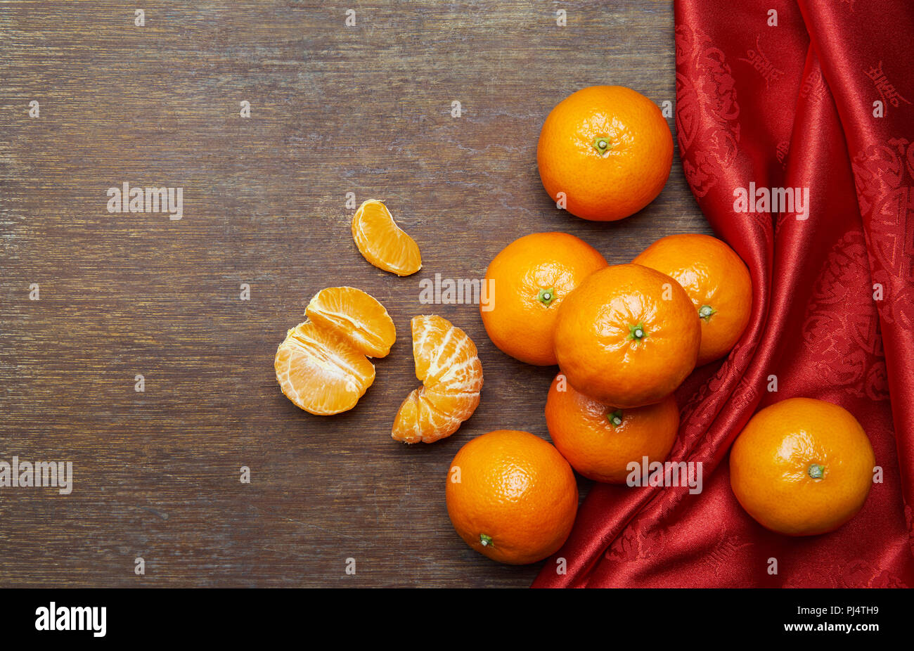 Chinese New Year - Mandarin oranges and red cloth on wooden table Stock Photo