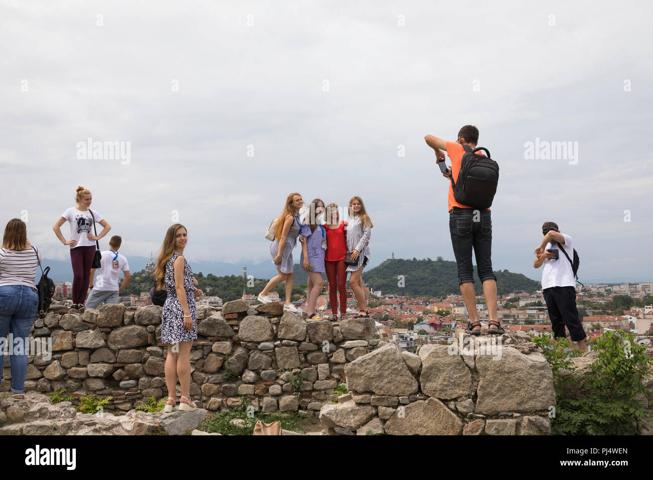Young people  making photo's of each other at the wall of Nebet Tepe, historical Roman and Thracian site at the old town of Plovdiv, Bulgaria Stock Photo