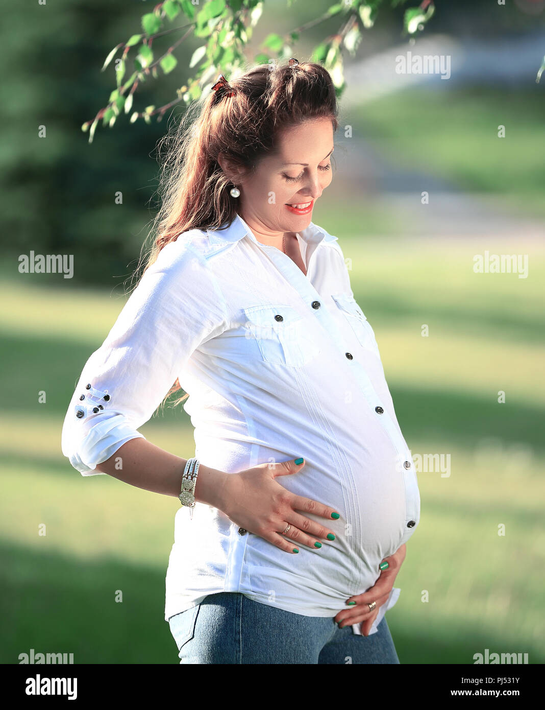 young pregnant woman on a walk in the Park on a Sunny day Stock Photo ...
