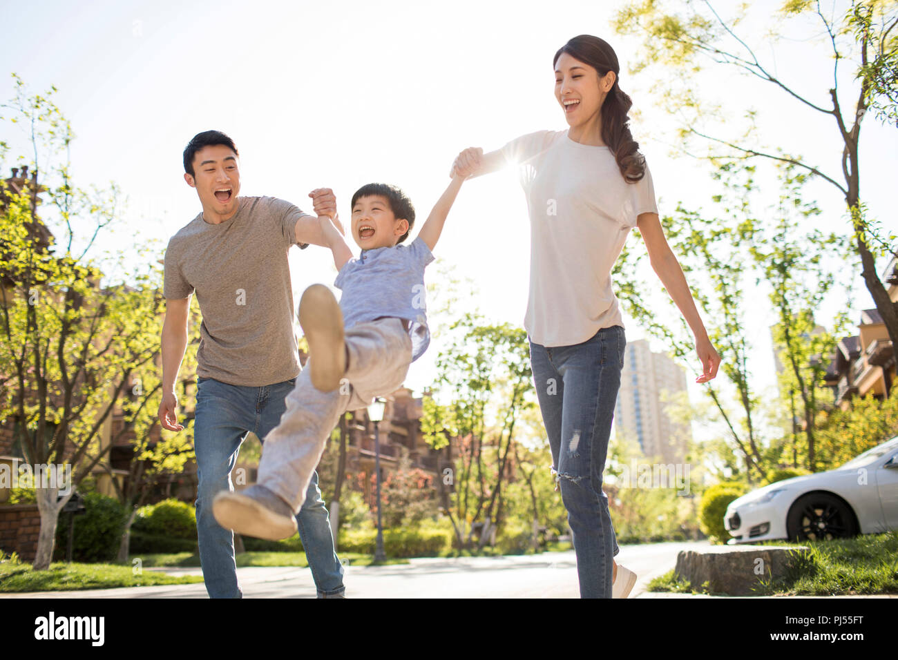 Happy young family playing outdoors Stock Photo - Alamy