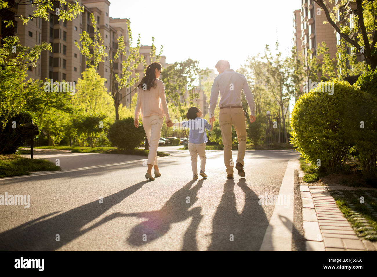Happy young family holding hands walking Stock Photo - Alamy
