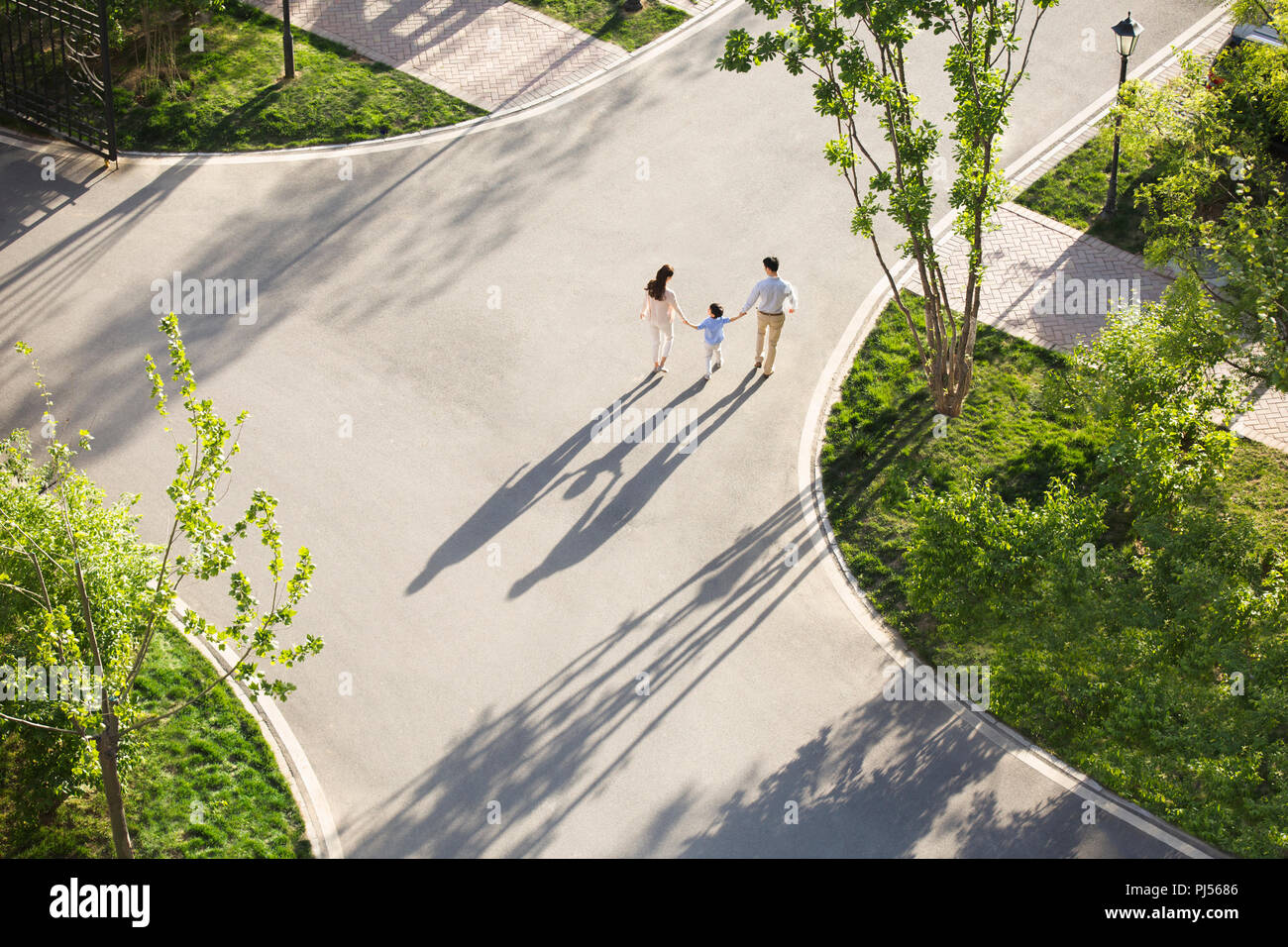 Happy young family holding hands walking Stock Photo - Alamy