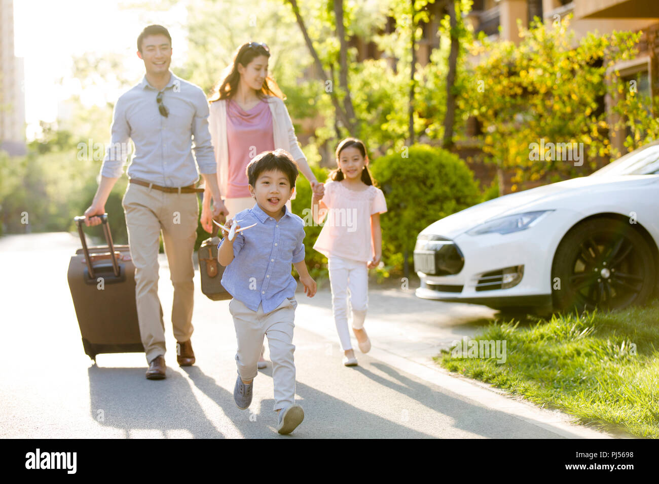 Happy young family going for vacation Stock Photo - Alamy