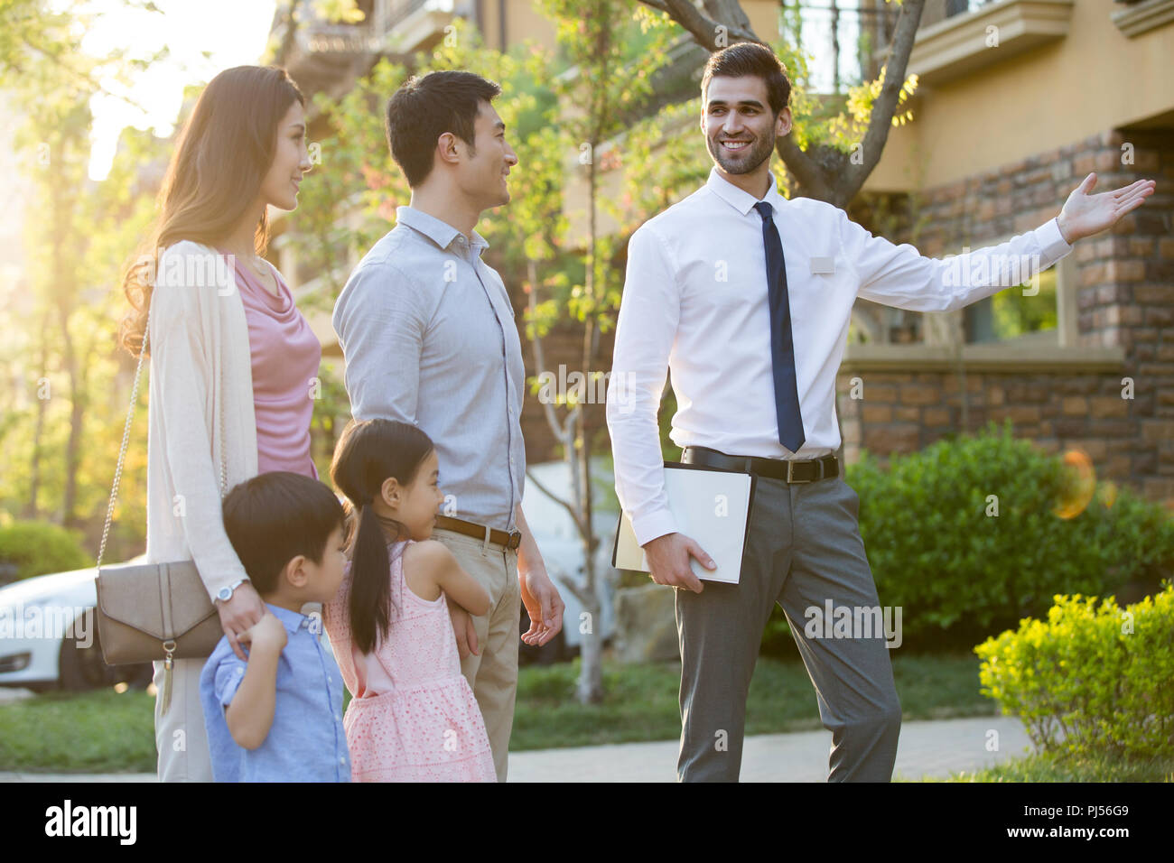 Happy young family and real estate agent Stock Photo Alamy