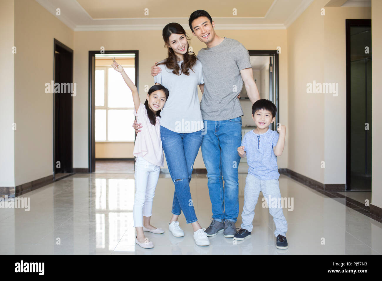 Happy young family holding keys in their new house Stock Photo - Alamy