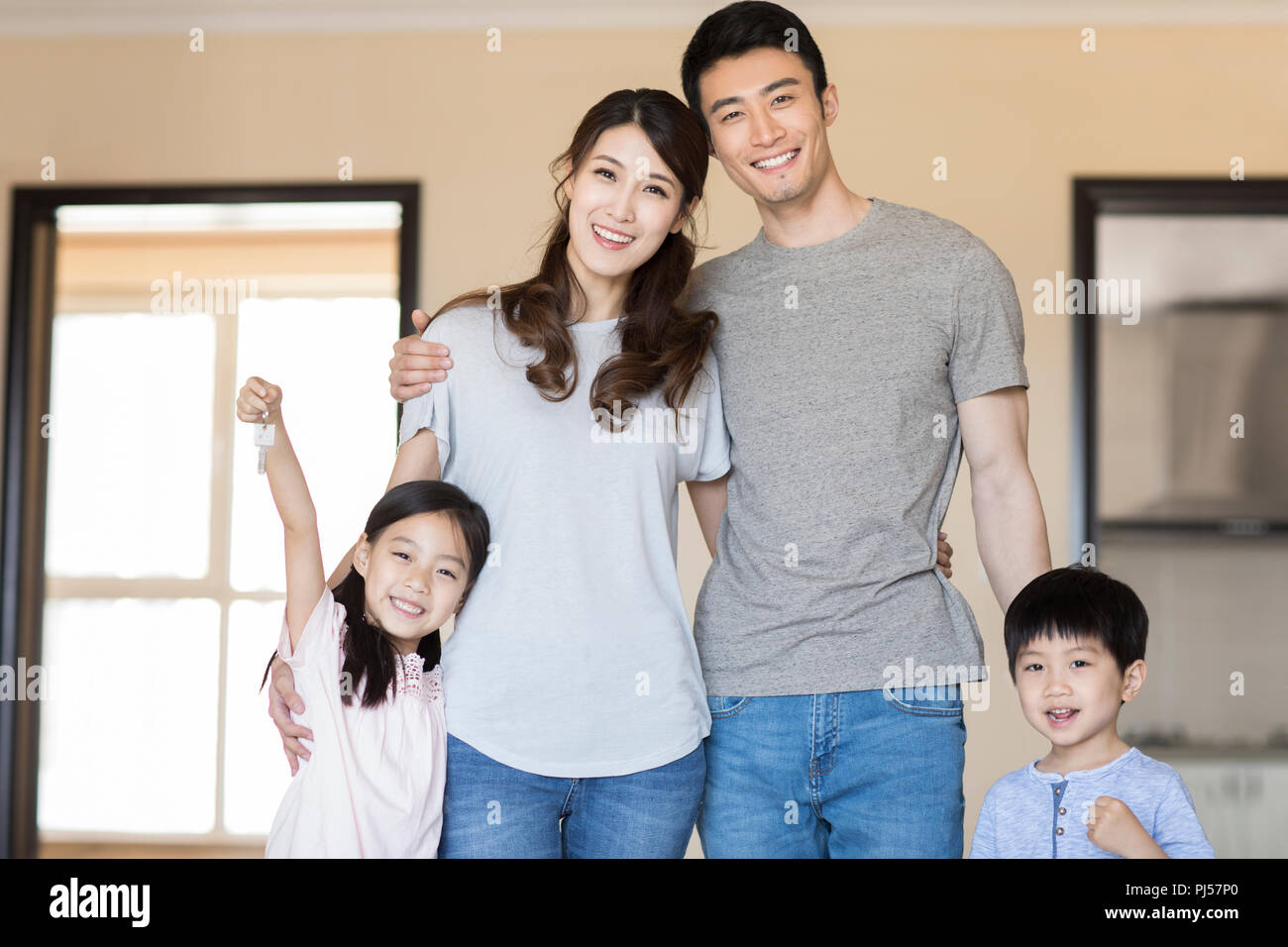 Happy young family holding keys in their new house Stock Photo - Alamy