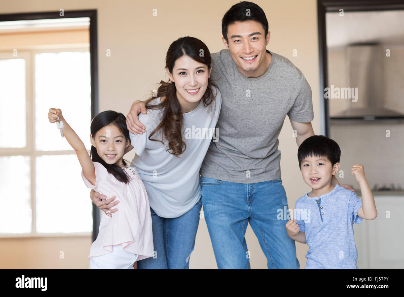 Happy young family holding keys in their new house Stock Photo - Alamy