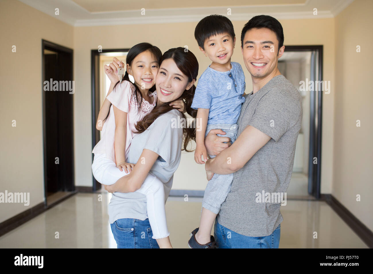 Happy young family holding keys in their new house Stock Photo - Alamy