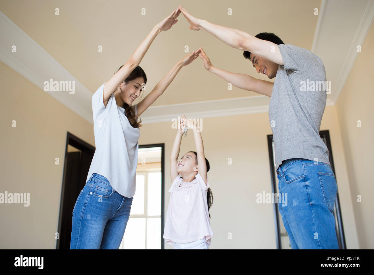 Happy young family holding keys in their new house Stock Photo - Alamy