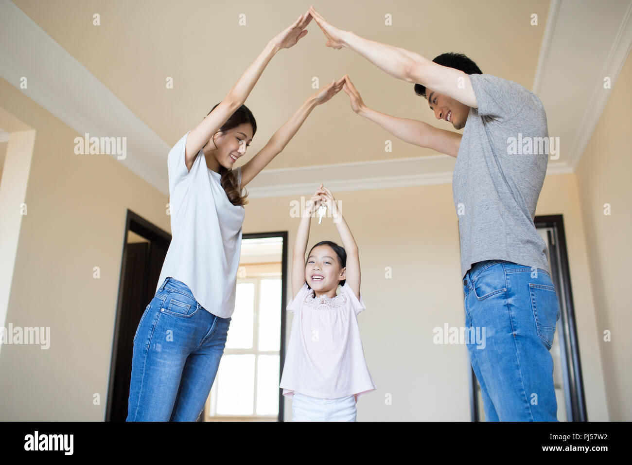 Happy young family holding keys in their new house Stock Photo - Alamy