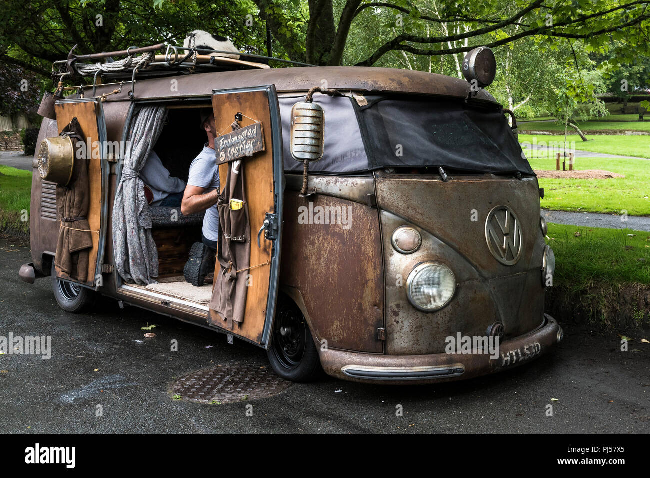 A vintage rat look Volkswagen camper van parked at the roadside. Stock Photo