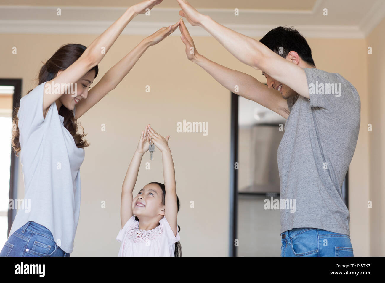 Happy young family holding keys in their new house Stock Photo - Alamy