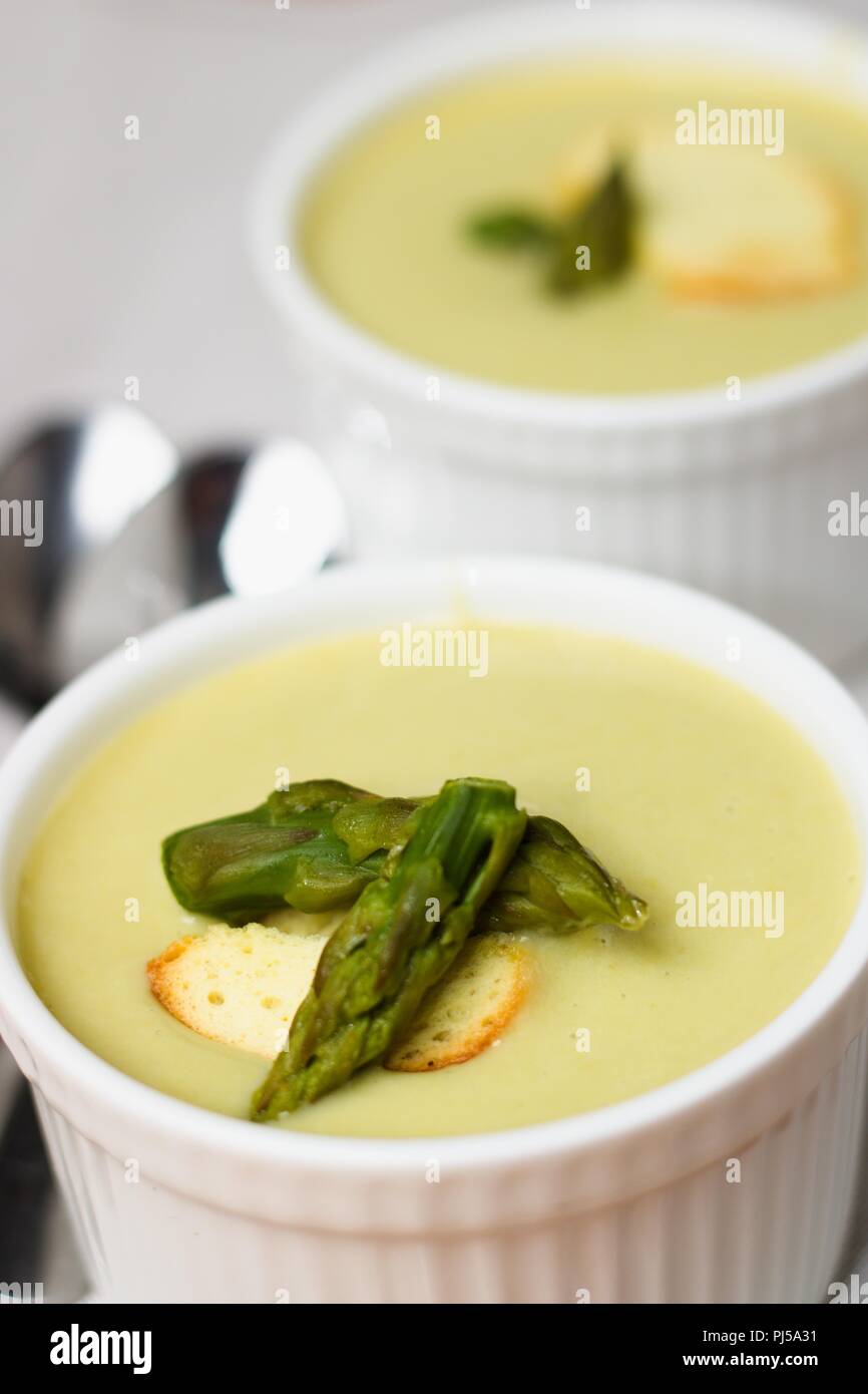 Two white cups of asparagus soup with creamy texture Stock Photo