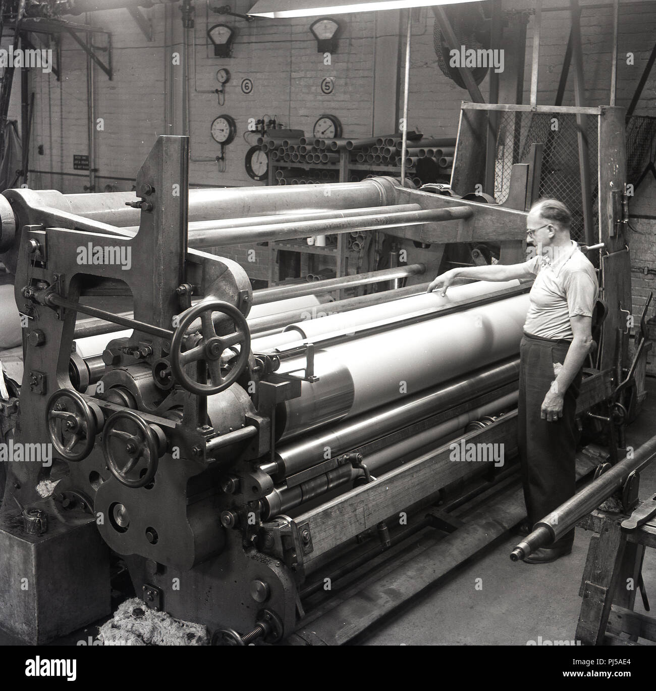 1950s, historical, At the Brittains paper mill, a male worker oversees