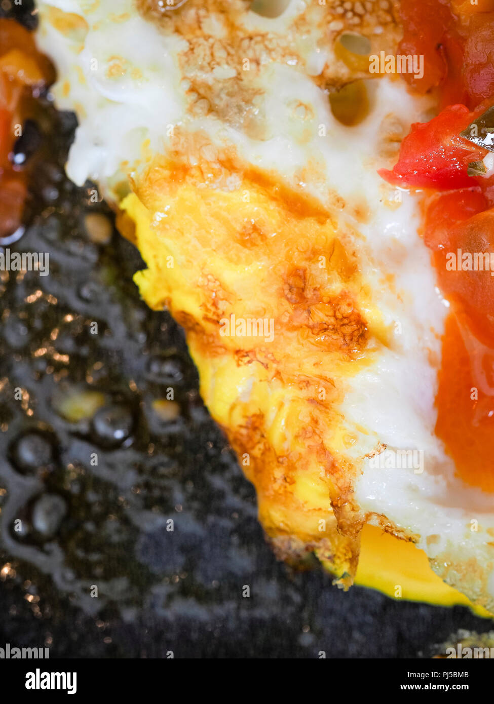 Frying eggs in a dark pan with butter Stock Photo Alamy