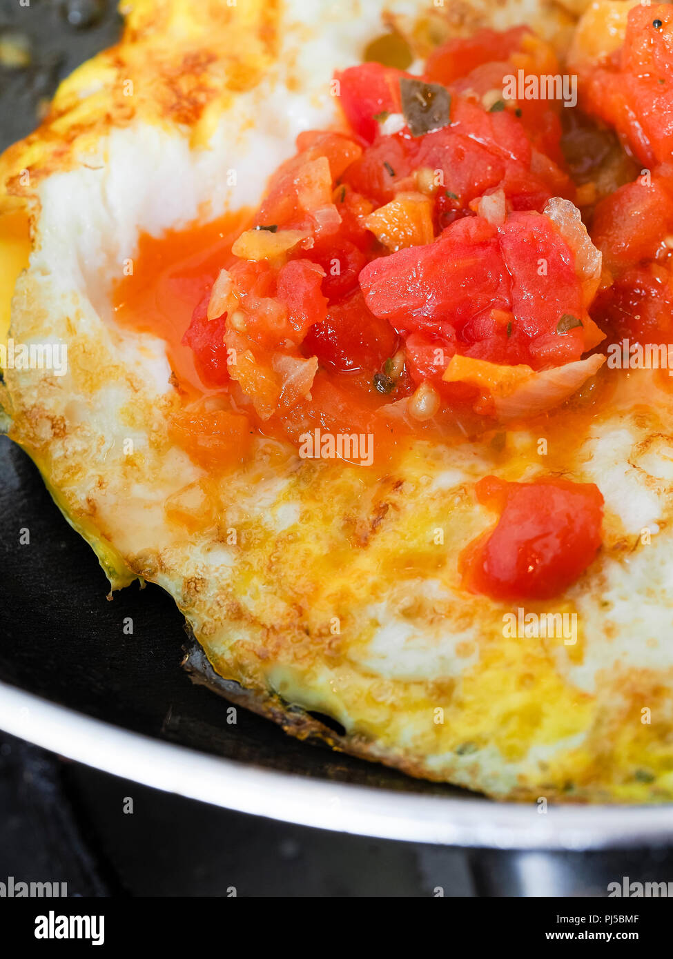 Frying eggs in a dark pan with butter Stock Photo Alamy